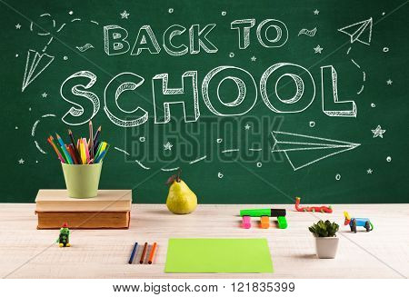 Back to school concepty with writing on blackboard and desk, apple, books, items