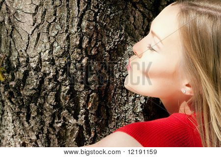 Mädchen küssen einen Baum - eine Metapher für Umweltschutz