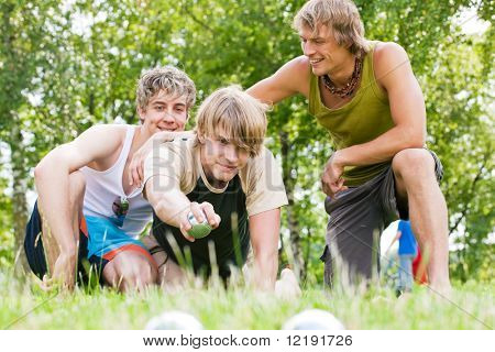 Gruppo di giovani uomini giocando boule in un parco