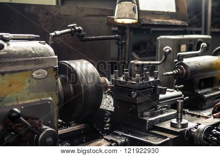 Old metal milling machine in factory closeup.