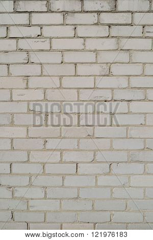 old light wall with broken bricks and cracks