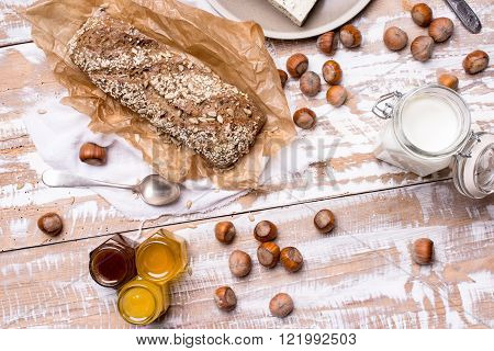 Bread With Honey Huzelnuts And Cheese On Wooden Board