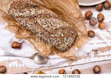 Bread With Seeds Huzelnuts On Wooden Board