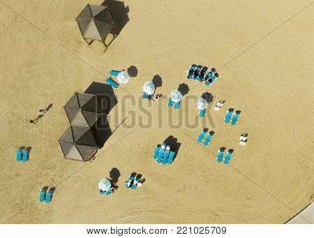 drone view of 3 beach hut with blue with blue beach beds