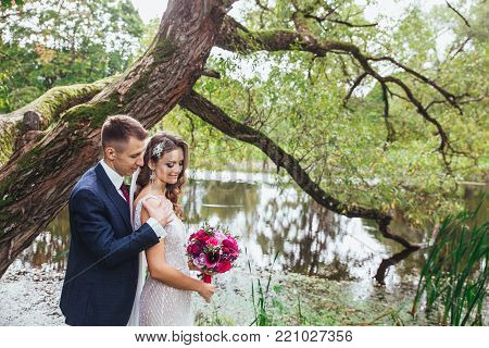 Happy bride and groom hugging on their wedding. wedding couple in park.Just merried.