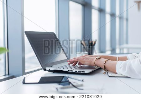 Female copywriter at her workplace, home, writing new text using laptop and Wi-Fi internet connection in the morning