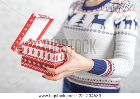 Christmas gift box in female hands, clopse up view