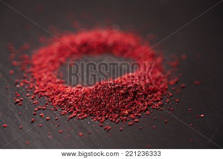 Ground Red Sumac Berries spice on black plate