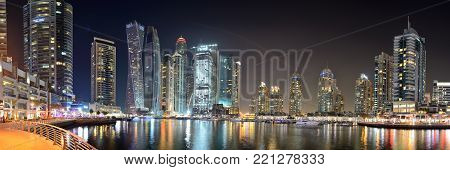 DUBAI, UAE - NOVEMBER 19: The night illumination of Dubai Marina and Cayan Tower on November 19, 2017 in Dubai, UAE. It is an artificial canal city, built along a two mile (3 km) stretch of Persian Gulf shoreline.