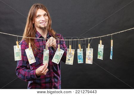 Riches and fortune. Young happy man with a lot of money on black background. Winning the lottery concept.
