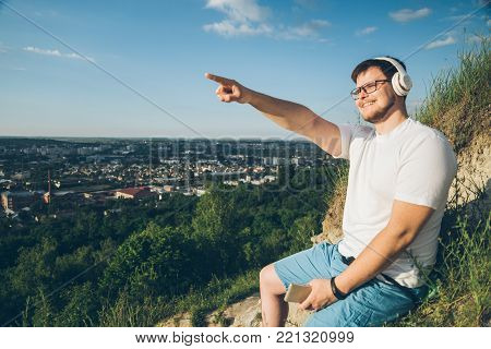 man listen music on the peak of the hill on sunset