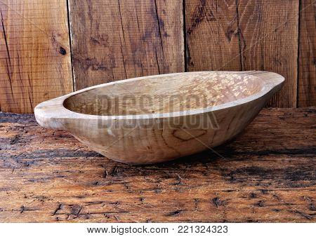 close on empty wooden bowl on brow and rustic plank
