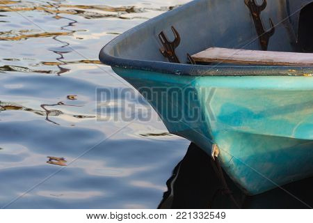 close up of small blue boat on reflective water