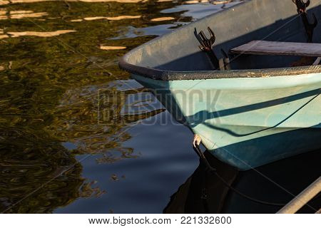 close up of small blue boat on reflective water