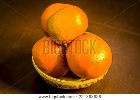 Close Up Of Fresh Ripe Oranges,citrus Aurantium In A Basket On Wooden Surface.