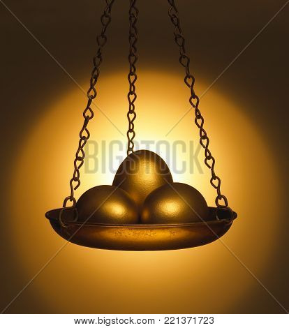 THREE GOLD EGGS IN BRASS PANIER OF ANTIQUE BALANCE