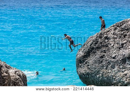 People Swim In The Sea At The Megali Petra Beach In Lefkada Island, Greece