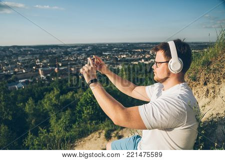 man listen music on the peak of the hill on sunset