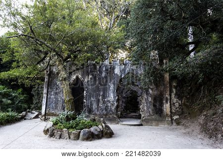 MONSERRATE, PORTUGAL - October 3, 2017: View of the fake ruins of a chapel, a popular romantic concept of the 1800s, being overrun by an Australian Banyan tree (ficus macrophylla) near Sintra