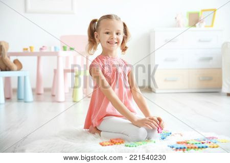Cute little girl playing with pazzles at home