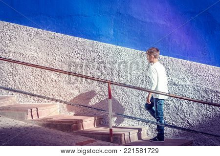 Young caucasian boy walking up stairs outdoors