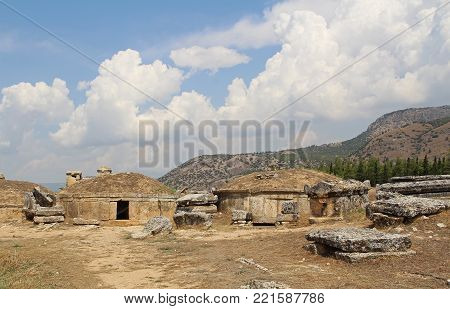 The ruins of the ancient Hierapolis city next to the travertine pools of Pamukkale, Turkey. Tumulus. The famous tourist destination in Turkey.