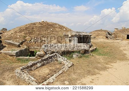 The ruins of the ancient Hierapolis city next to the travertine pools of Pamukkale, Turkey. Tumulus. The famous tourist destination in Turkey.