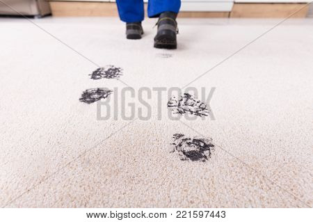 Elevated View Of Person Walking With Muddy Footprint On Carpet