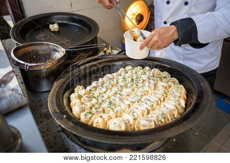 Sheng Jian Bao and Guo Tie being packaged - Shanghai pan fried dumplings in traditional pan