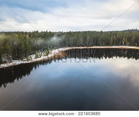 Aerial Drone Photograph of a Partly Frozen Lake in a Snowy Winter Day