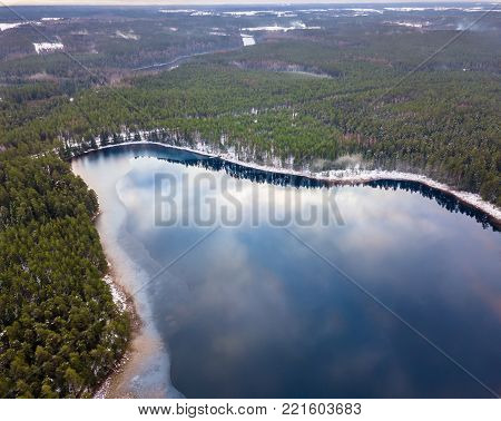 Aerial Drone Photograph of a Partly Frozen Lake in a Snowy Winter Day