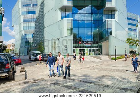 TIRANA, ALBANIA - SEPTEMBER 6, 2017: Unknown people walk along street near large modern shopping center Toptani, Tirana, Albania