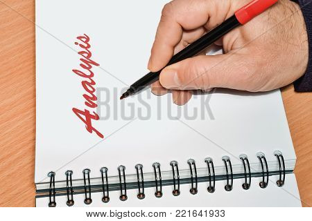 Closeup of a notebook and handwritten word Analysis in red color