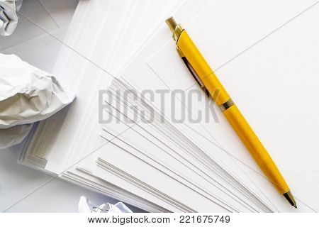 writer at work crumpled white paper ballpoint pen on a white background, indoors