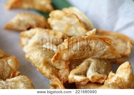 Close up portion of traditional Chinese Jiaozi deep fried dumplings on paper, high angle view