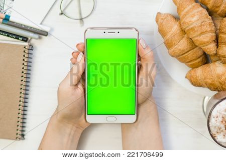 Beautiful girl holding a smartphone in the hands of a green screen green screen, hand of man holding mobile smart phone with chroma key green screen on white background, new technology concept
