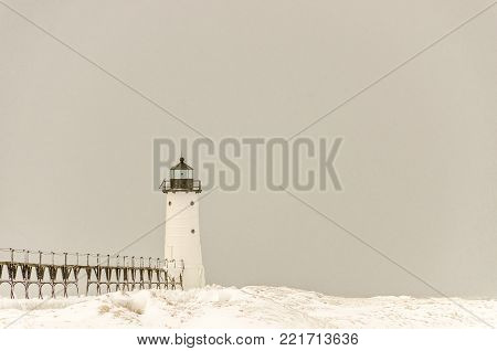 Snow is falling on the catwalk and light at Manistee, Michigan