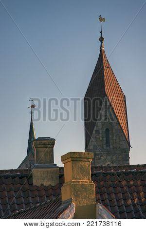 Cathedral tower and spire close to roofs and chimneys in Ribe, Denmark.