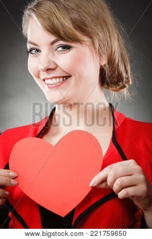 Love and help from people. Charming lovely woman with red paper heart persuade to be good helpful hopeful. Valentines Day or charity concept.