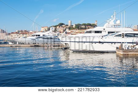 Cannes, France - November 21, 2017:  luxury boats in the marina with Le Sequet old town in tha background