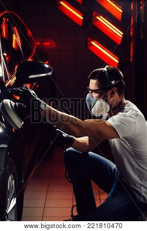 Car polish wax. worker hands holding a polisher and polish car