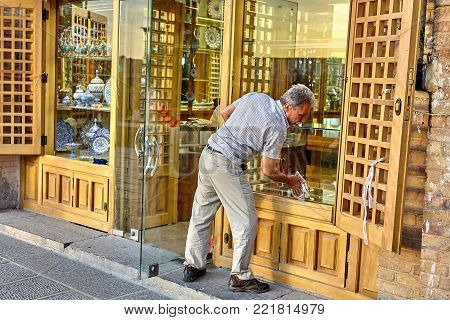 Isfahan, Iran - April 23, 2017: The trader washes the shop window in the china store, which is located on Naghshe Jahan Square.