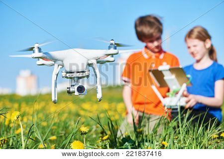 children operating of flying drone at sunset