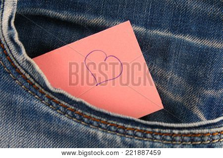 Heart - a symbol of love peeps out of the pocket of jeans trousers. The concept of the day of lovers. St. Valentine's Day