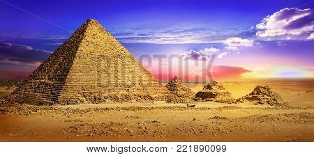 Pyramids in desert under ultra violet clouds
