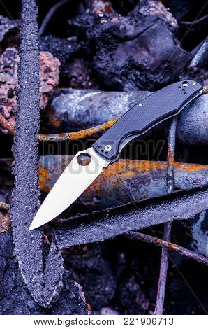 EDC knife. Knife lying on rusty darts.