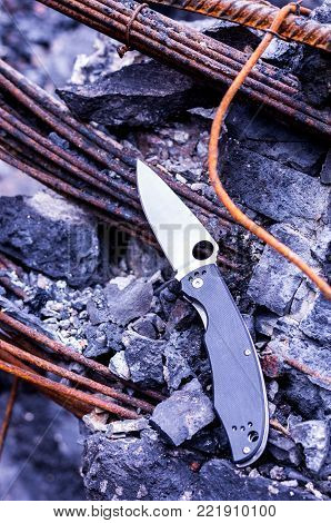 A knife on a broken beam. Catastrophe in outdoors. Vertical shot.