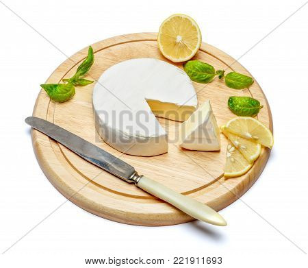 Round brie or camambert cheese on cutting board isolated white background