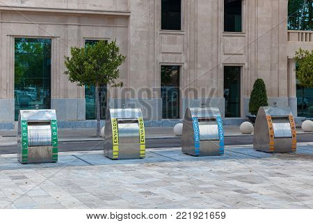 Palma de Mallorca, Spain, garbage cans of four kinds on the background of the building. Trash bins in Spain.