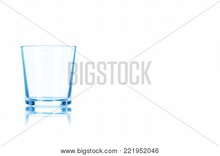 Empty glass of whiskey toned in blue colorisolated on a white background. Place for your text.
